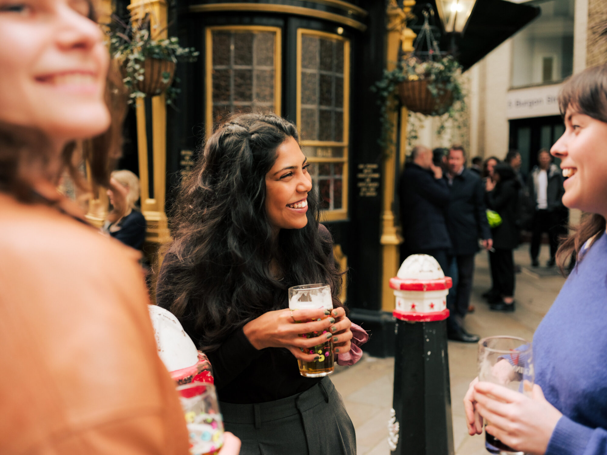 Food and Drink - Group of friends outside heritage pub in the City - hanging flower baskets in background