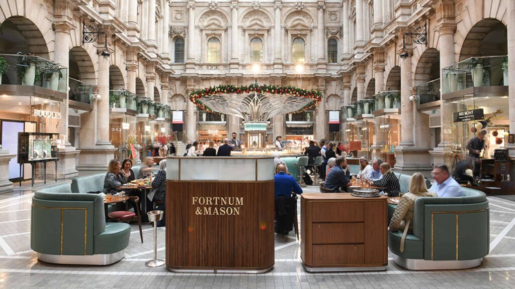 The Fortnum's Bar & Restaurant at The Royal Exchange - view of the interior of the royal exchange - stone archways surround the courtyard with Fortnum's bar in the middle - large oval bar with causal seating