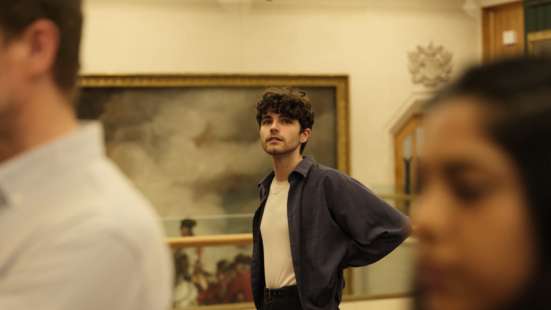 Man looking at paintings in an art gallery