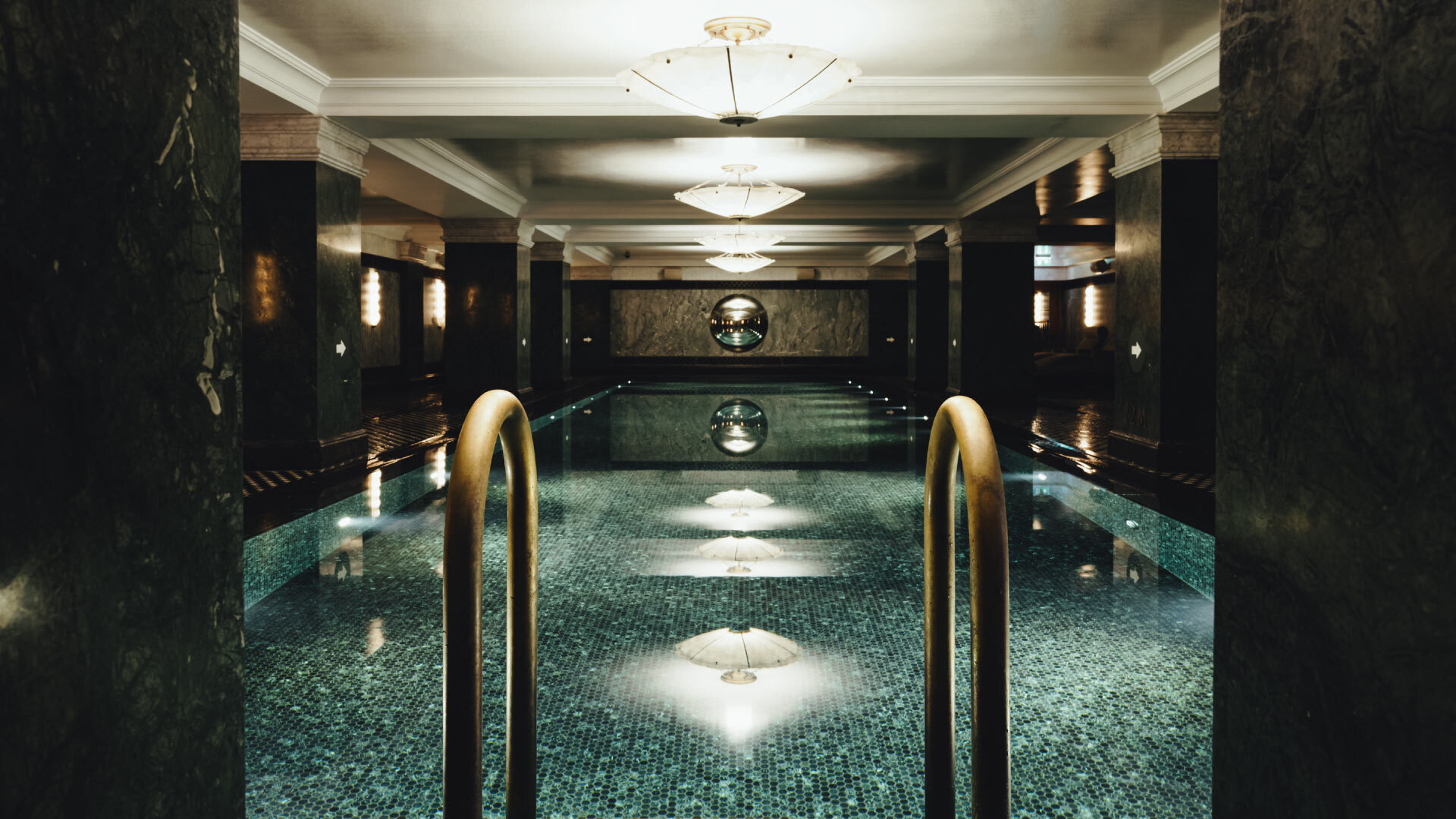 5 best Spas in the City of London - The Ned Spa - indoor pool, long tiled pool, black marble pillars surrounding it