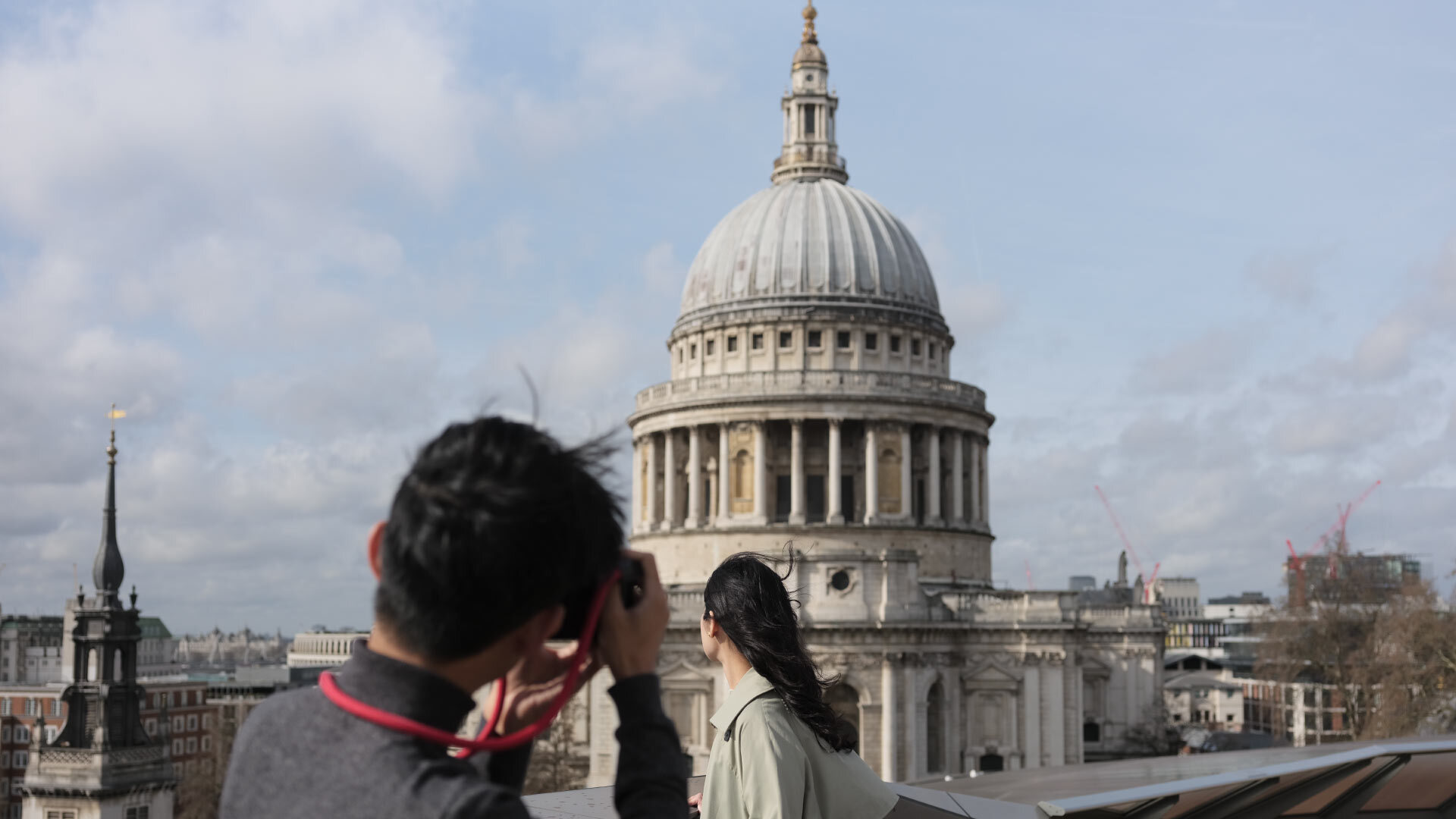 8 best Instagrammable places in London - Roof Terrace at One New Change - man taking picture of woman on balcony with a view of St Paul's 