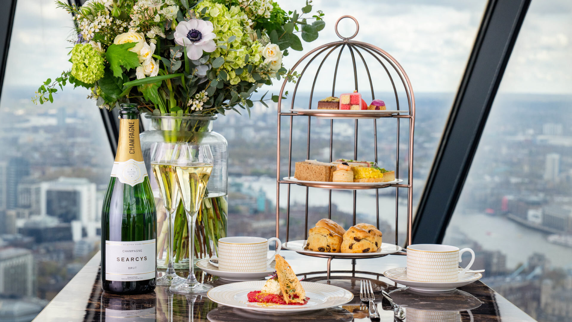 11 Rooftop Bars & Restaurants in the City of London - Searcys at The Gherkin - table with fizzy wine, tea cups and a cake stand