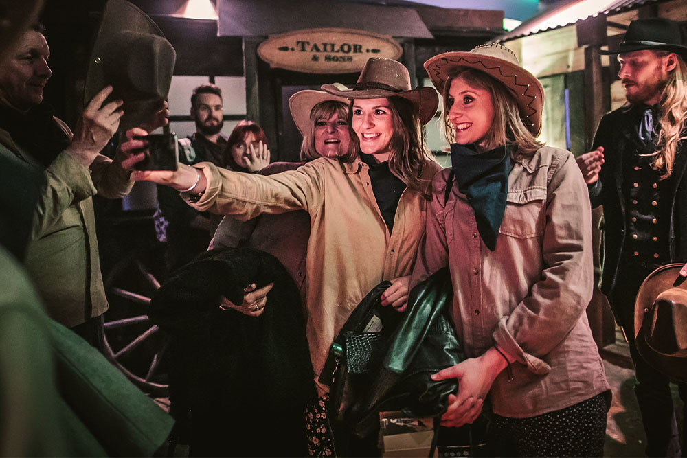 Must-try immersive experiences in London - Moonshine Saloon - group of friends wearing cowgirl outfits taking a Selfie  