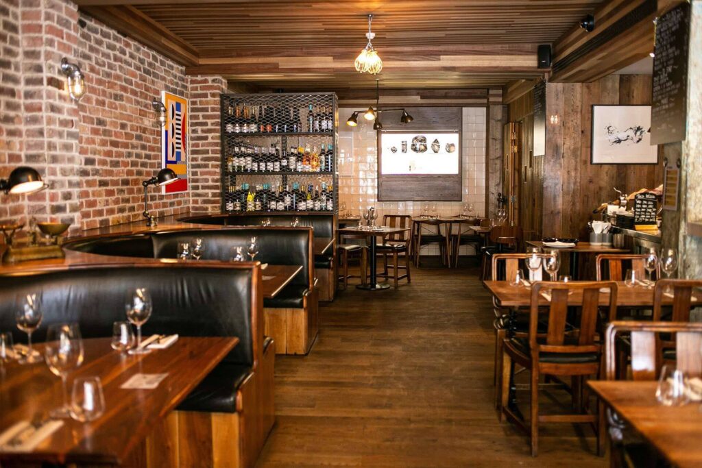 9 Best Brunch Spots in the City of London - Jose Pizarro - bare brick walls, leather booth seating and racks of wine