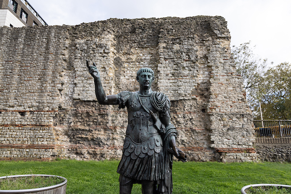 Roman City Wall, with a statue of a Roman in front.