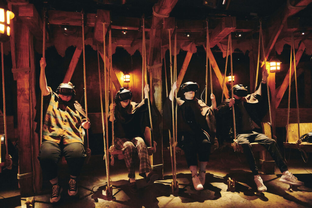 The Gunpowder Plot - Must-try immersive experiences in London - the gun powder plotVR experience - group of people sat on rope swings with VR headsets on