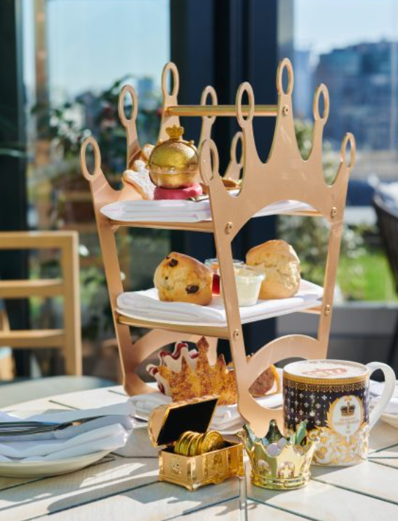 An afternoon tea served on a cake stand shaped like a crown.