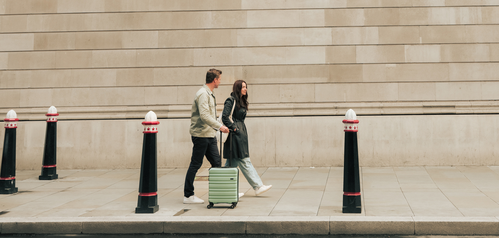 Things to do in the City of London - man and woman walking on city pavement with luggage