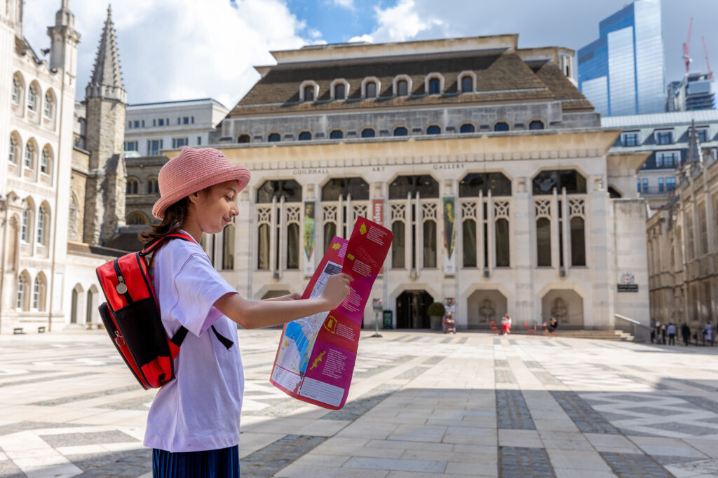Plan your visit - City Children’s Visitor Trail reduced - young girl looking at a map of the City in front of the Guildhall Gallery