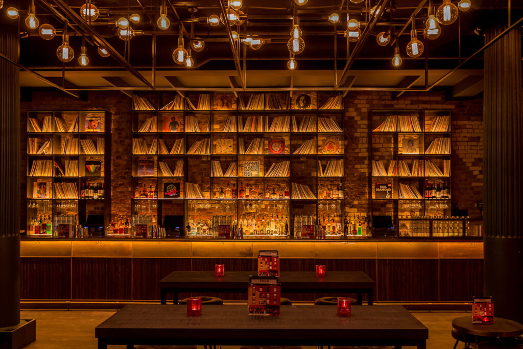 Eastcheap Records - a orange lit bar with records all over the walls and an empty counter top