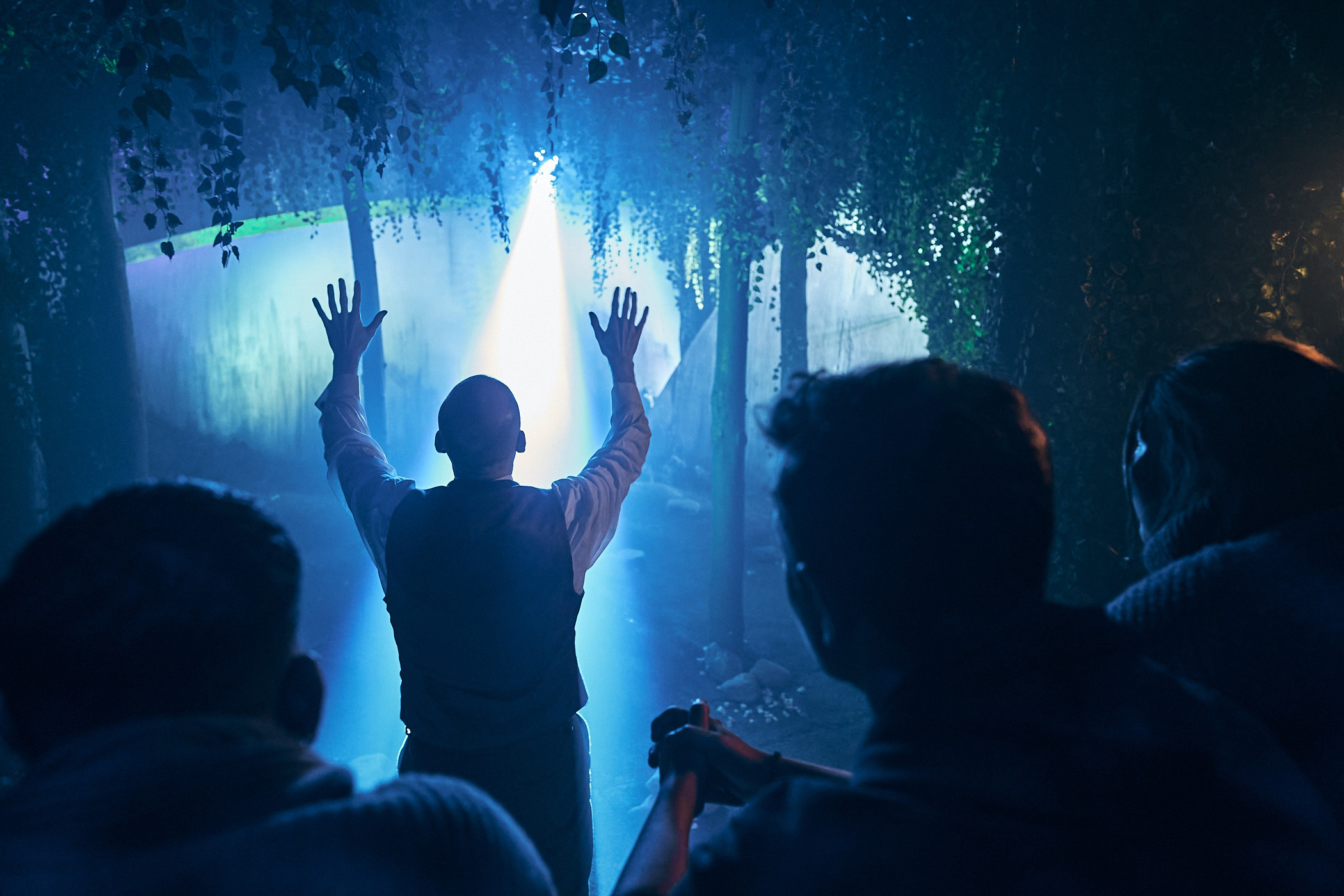 Must-try immersive experiences in London - Jeff Wayne’s The War of the Worlds - The Immersive Experience - theatrical set with beam of light shining down on man holding up his hands