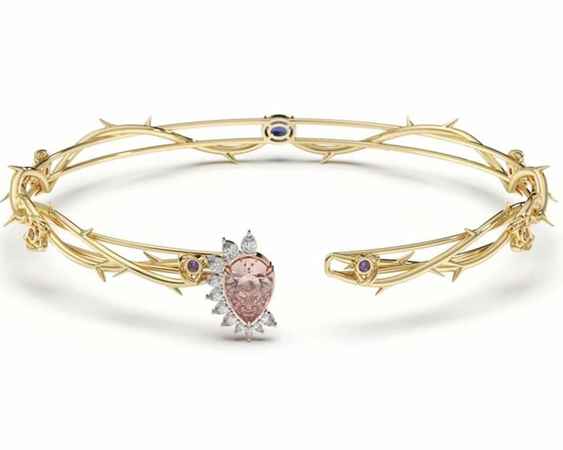 Gold bracelet with pink gem on one of its ends
