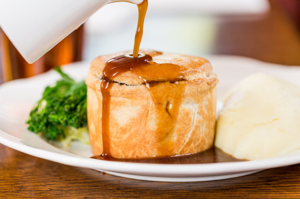 The Butchers Hook & Cleaver - close up of a pie with gravy pouring over it