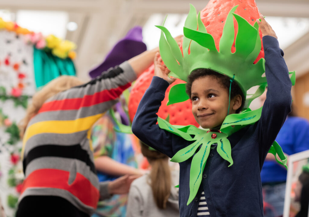 Kid wearing a giant strawberry hat