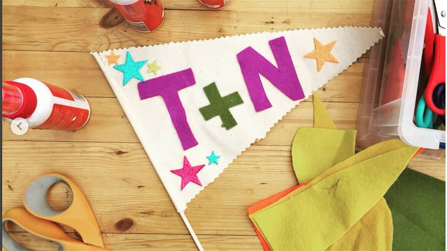 Hand-made flag featuring coloured stars and the characters T+N on a wooden table