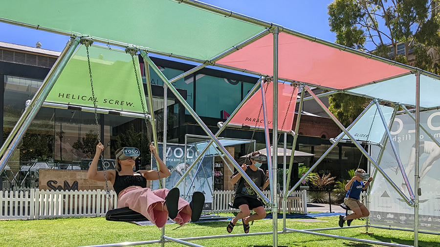 people on swings with vr headset