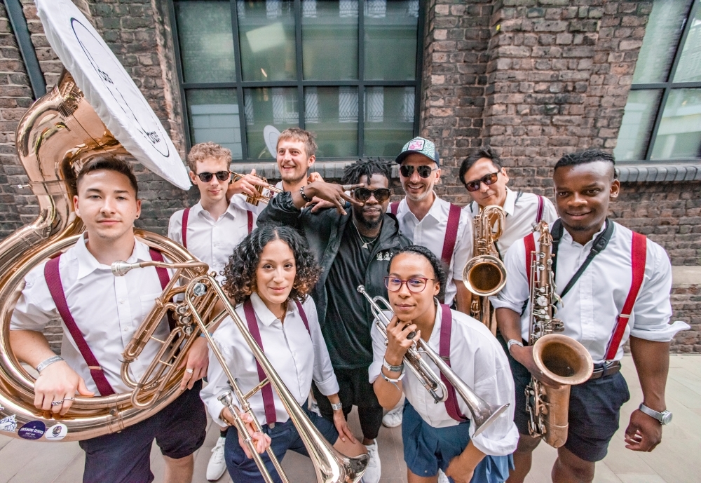 A group of musicians standing up and holding their instruments.