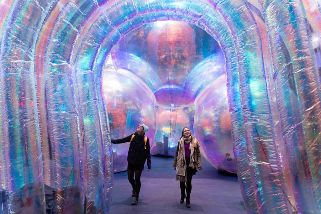 A 20ft-high, rainbow-coloured arc with two people standing underneath it.