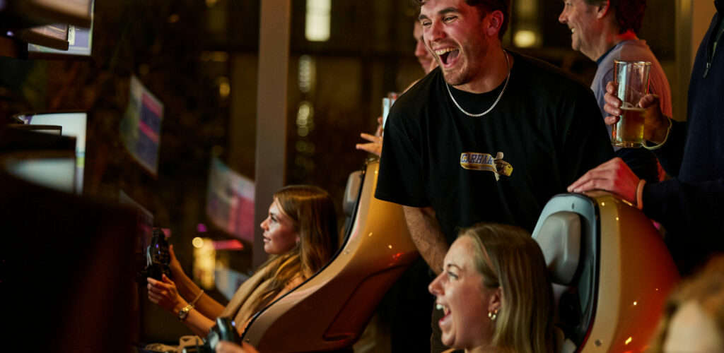 A group of people playing video games at a bar.