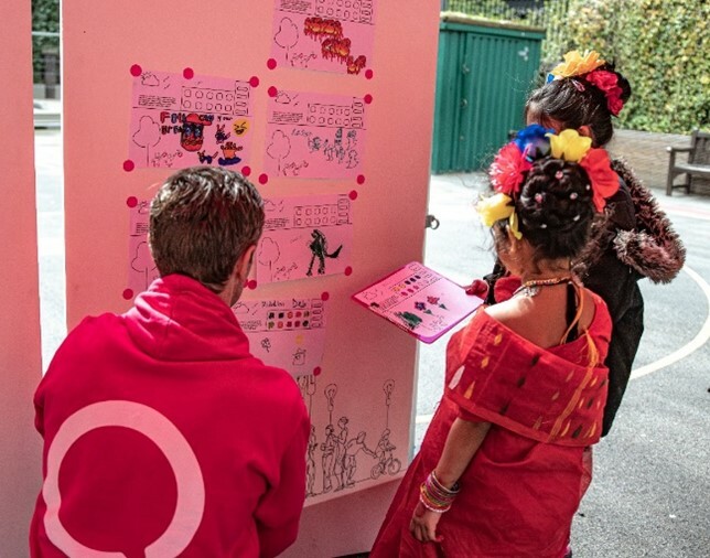 Three people looking at a wall with writing and drawings.