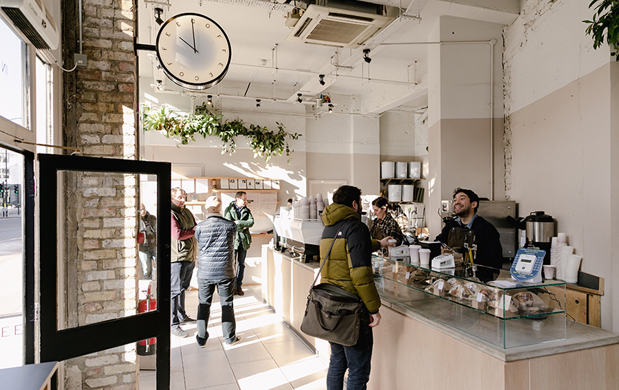 Customers waiting at the counter of a coffee shop.