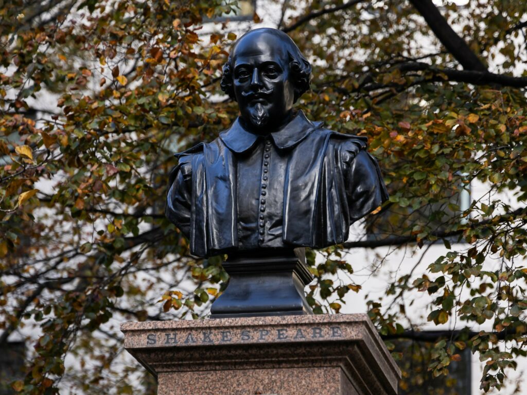 Statue of British playwright William Shakespeare - head and shoulders - on top of a plinth with the word "Shakespeare"