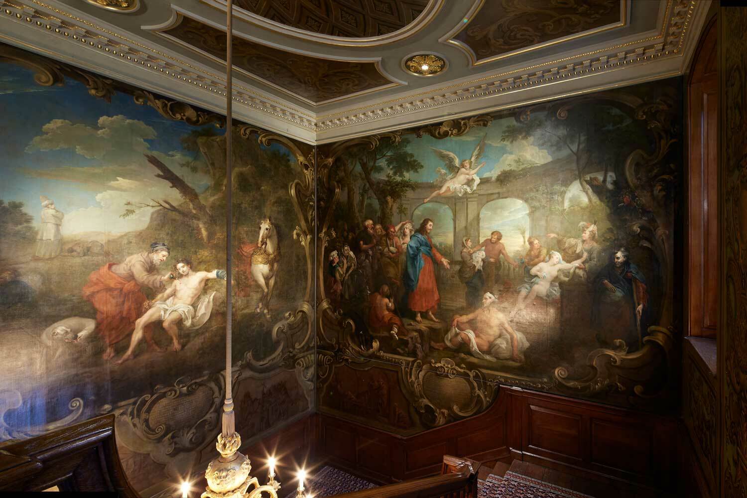 An ornate staircase, decorated with wall paintings