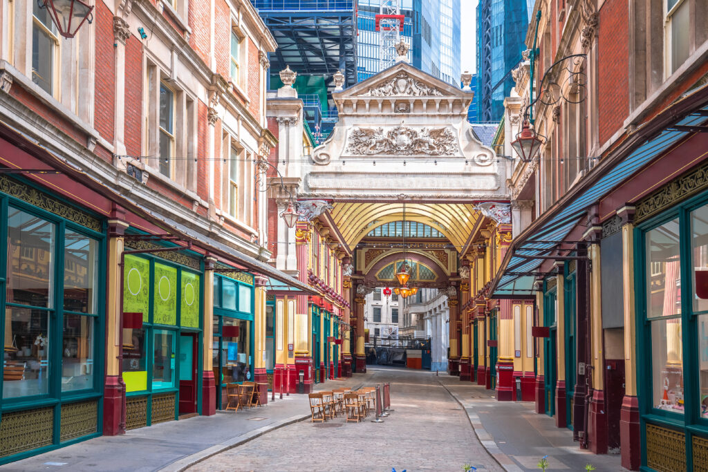Entrance to the Victorian Leadenhall Market, with colourful shopfronts on either side of a cobbled street.