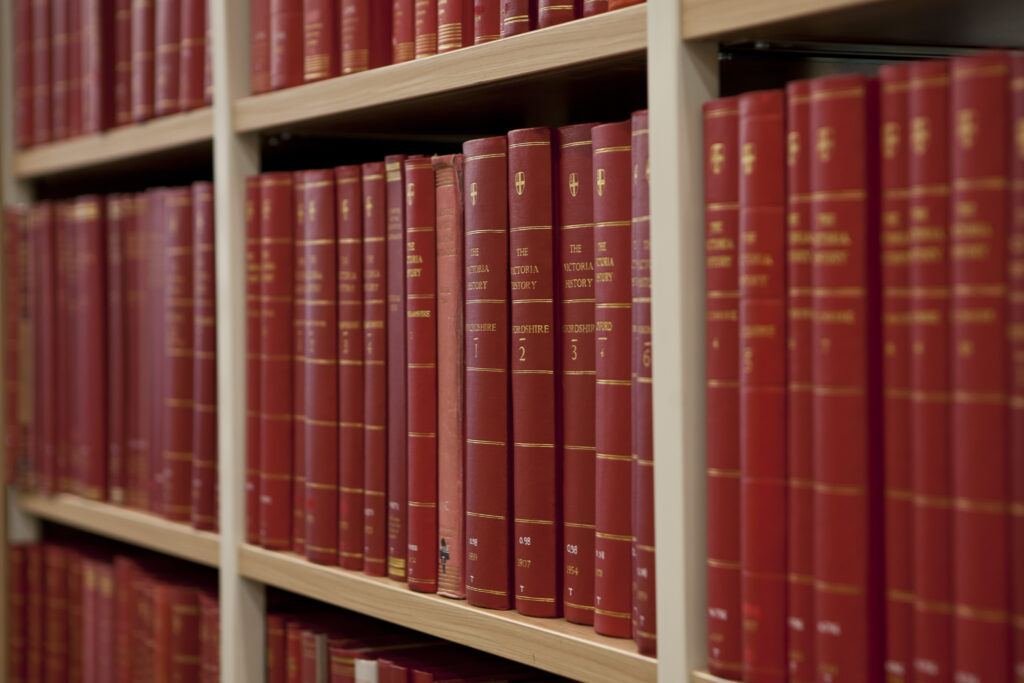 Line of red books with gold text.