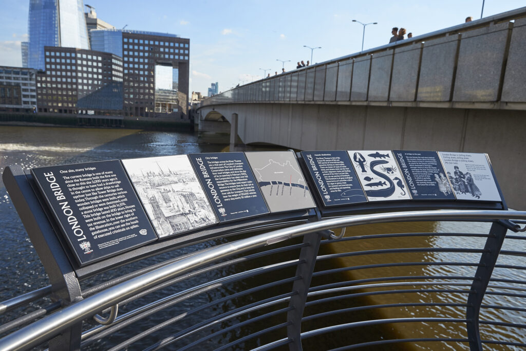 View of London Bridge and River Thames. Information on the history of London Bridge is displayed on a viewing platform overlooking the river.
