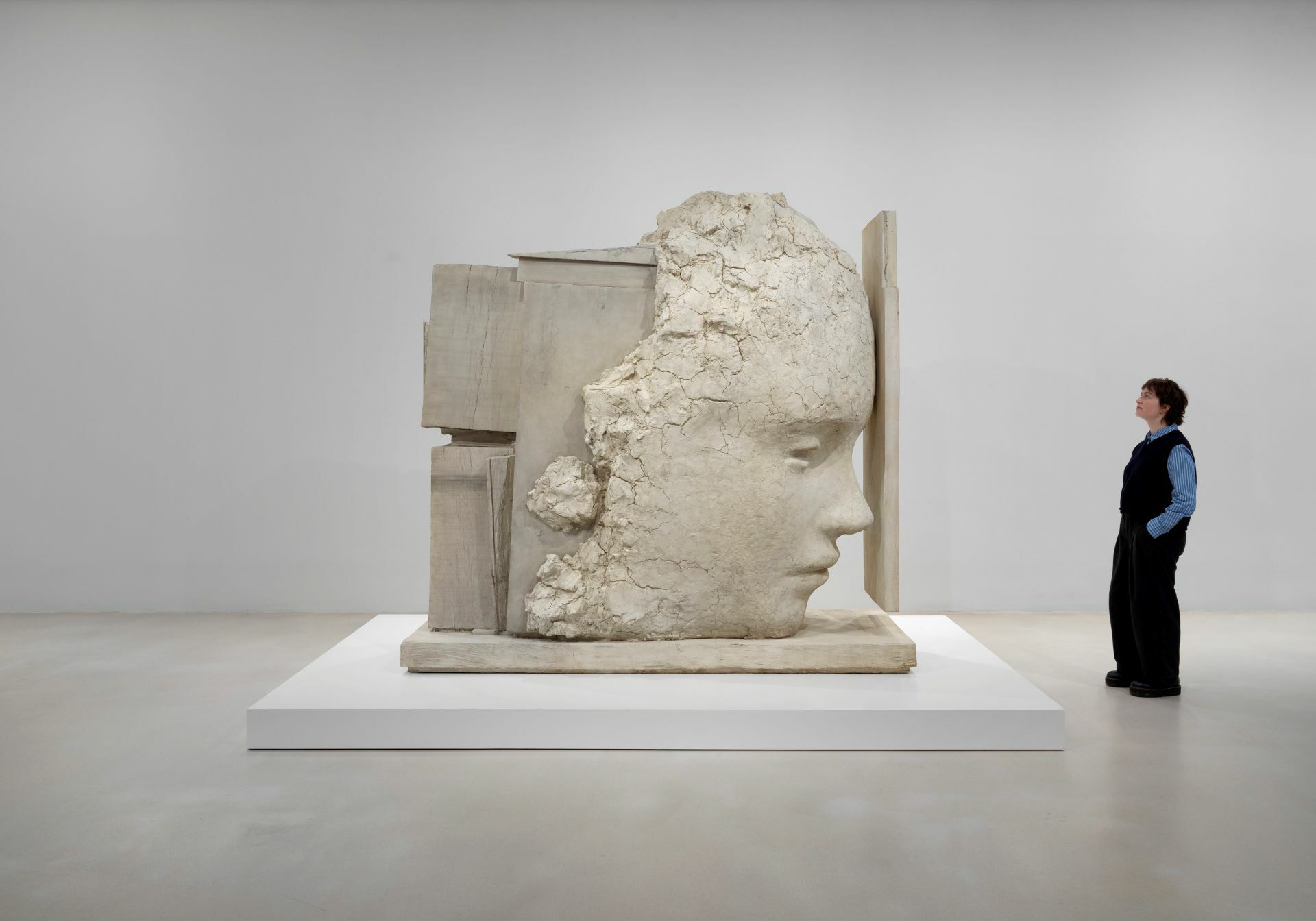 A person is looking at a monumental sculpture in an art gallery