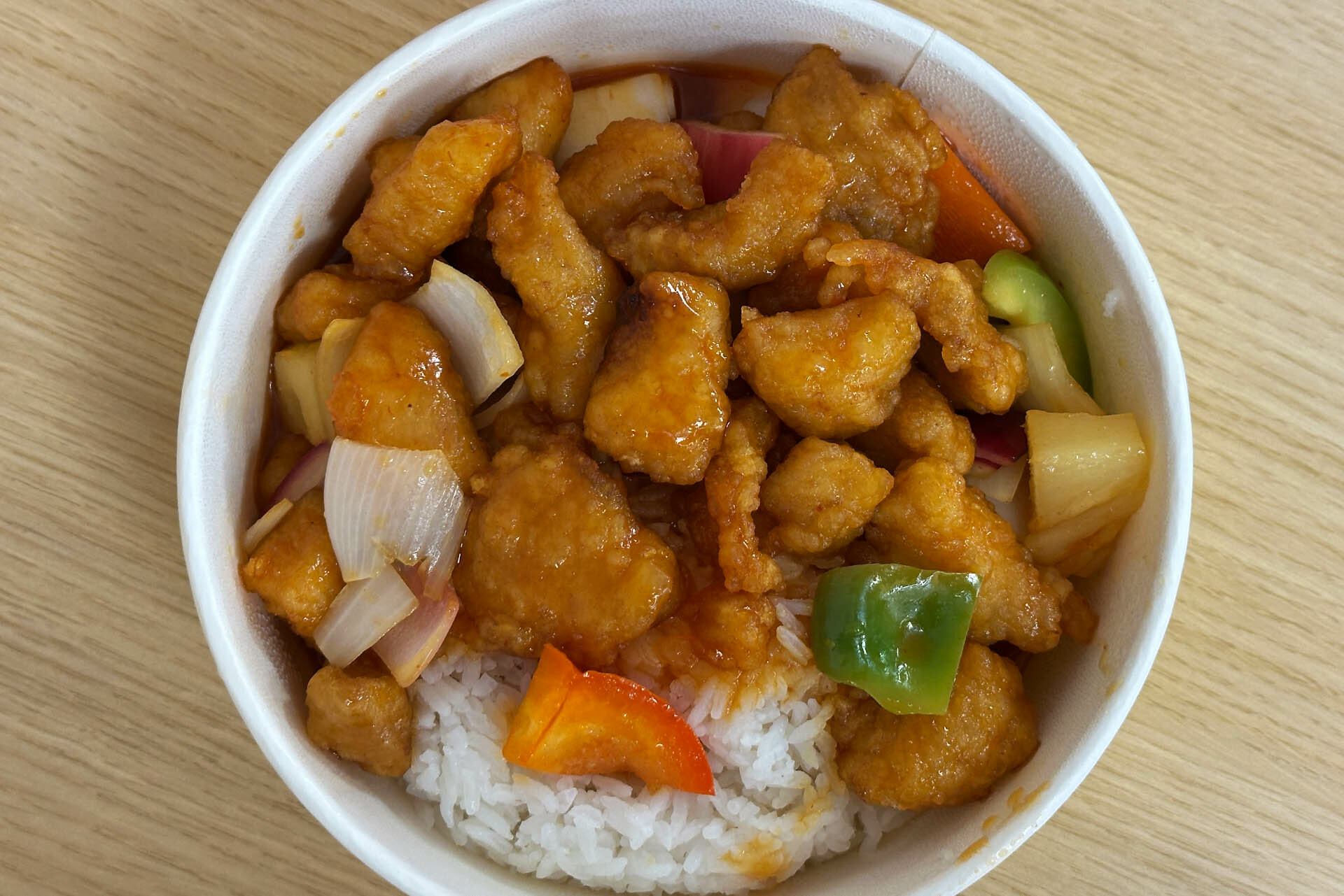 Top level shot of a round bowl of sweet & Sour chicken