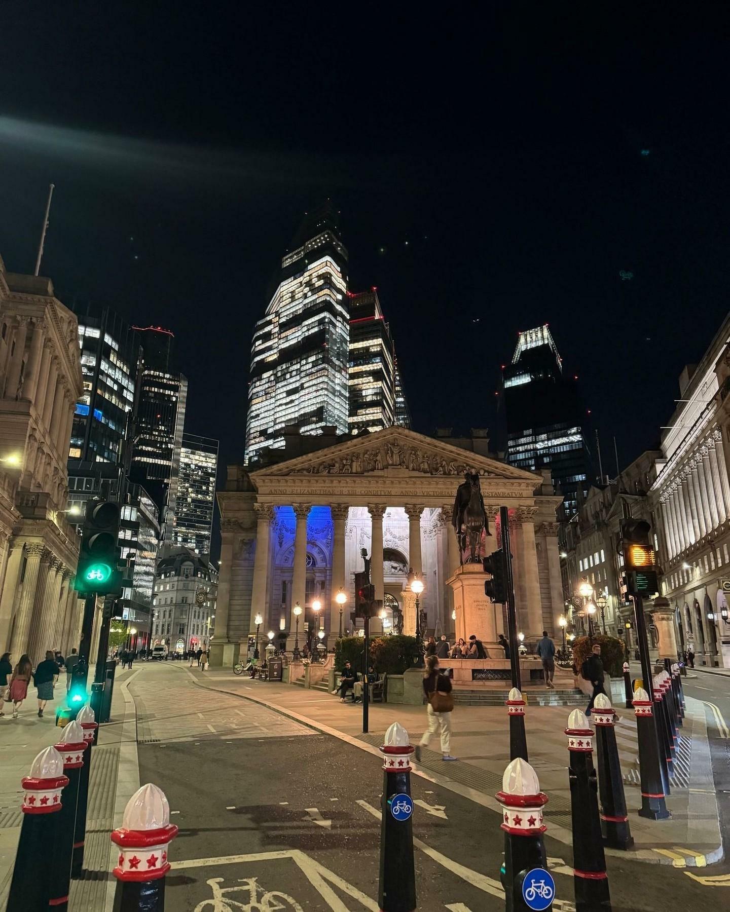 Image taken of The Royal Exchange with the City skyline behind it at night