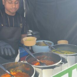A worker ladelling Ethiopian food into a bowl