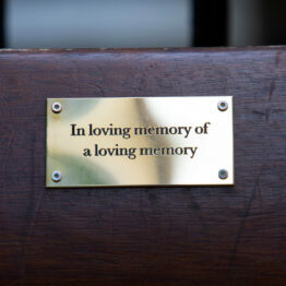 A bench plaque which reads 'in loving memory of a loving memory'