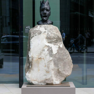 Large stone sculpture at the centre with a metal head at the top